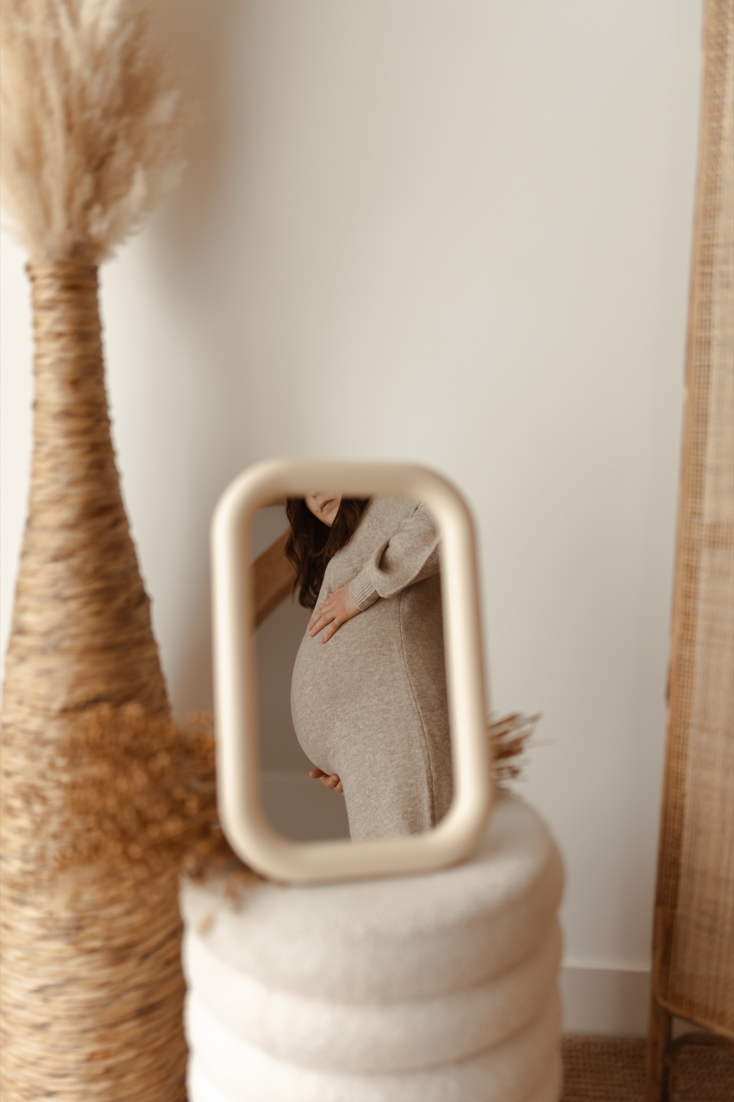 Femme enceinte se regardant dans un miroir, les mains posées sur son ventre